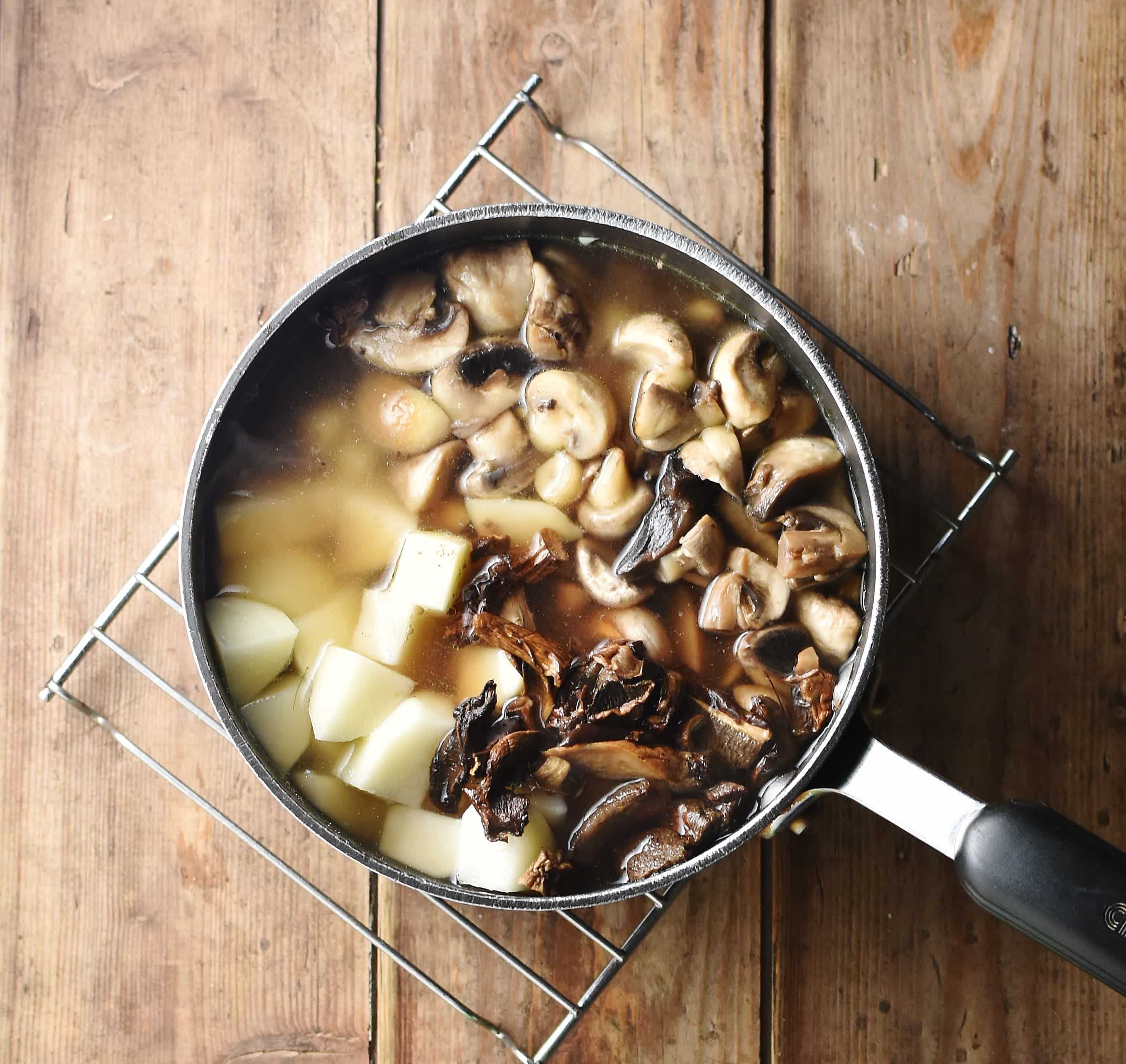 Mushrooms and cubed potatoes in large pot with water.