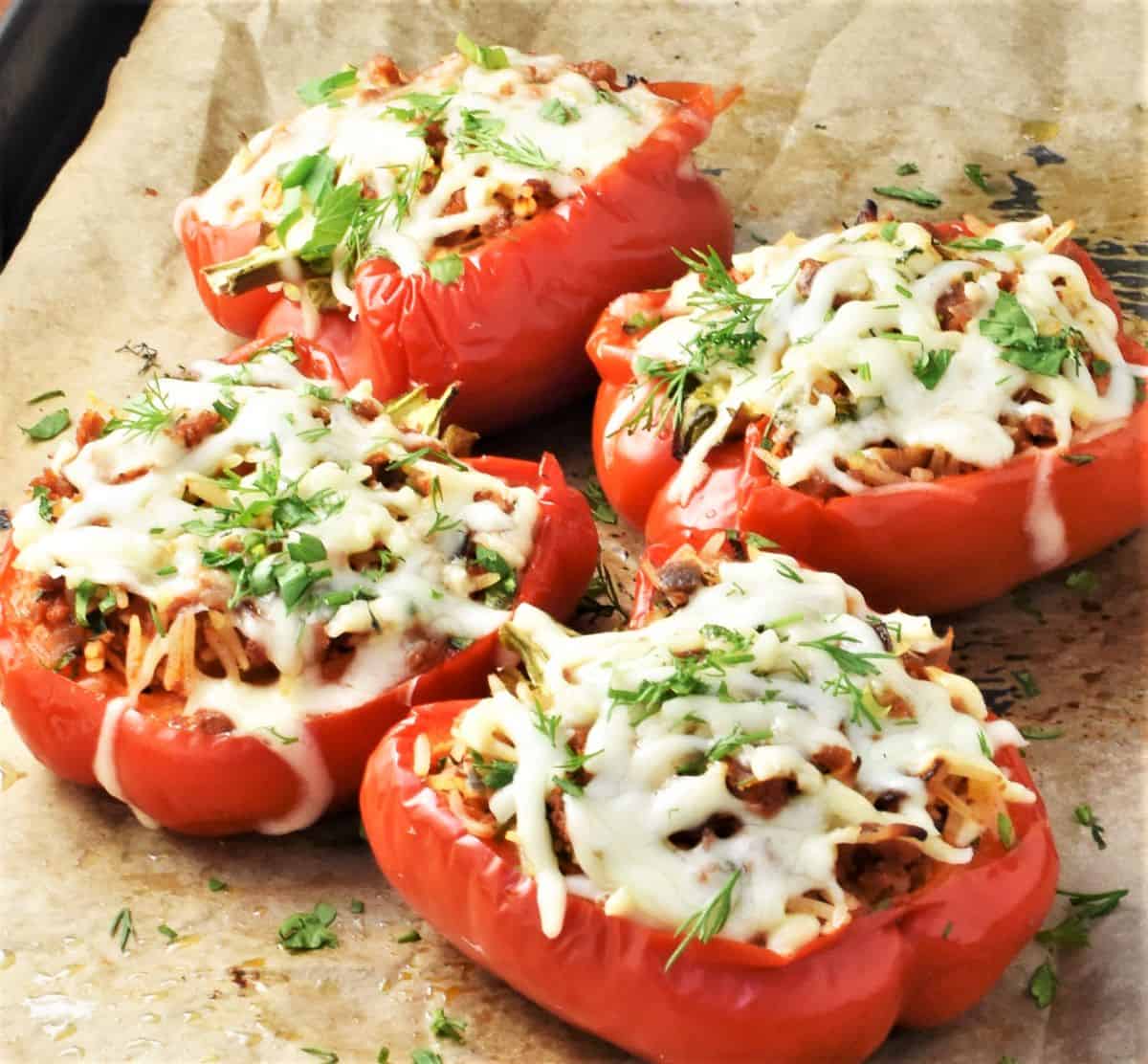 Side view of stuffed peppers with rice and turkey on top of parchment.