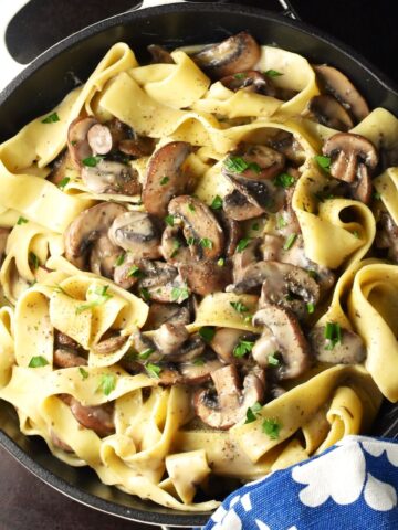 Top down view of mushroom pasta without cream in shallow pan.