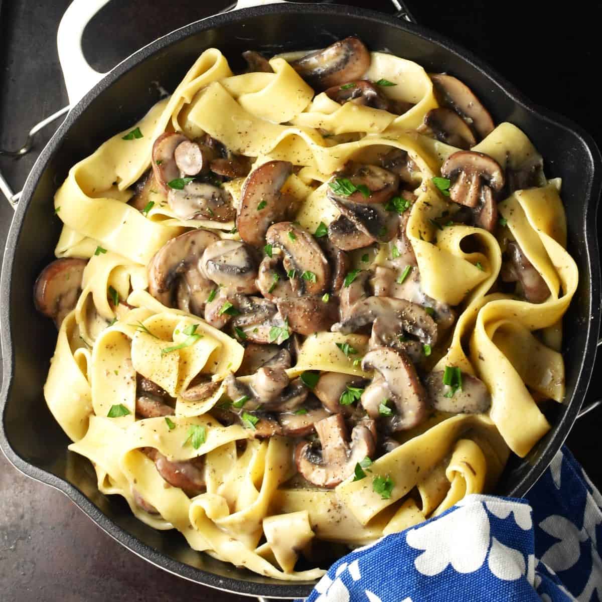 Top down view of mushroom pasta without cream in shallow pan.