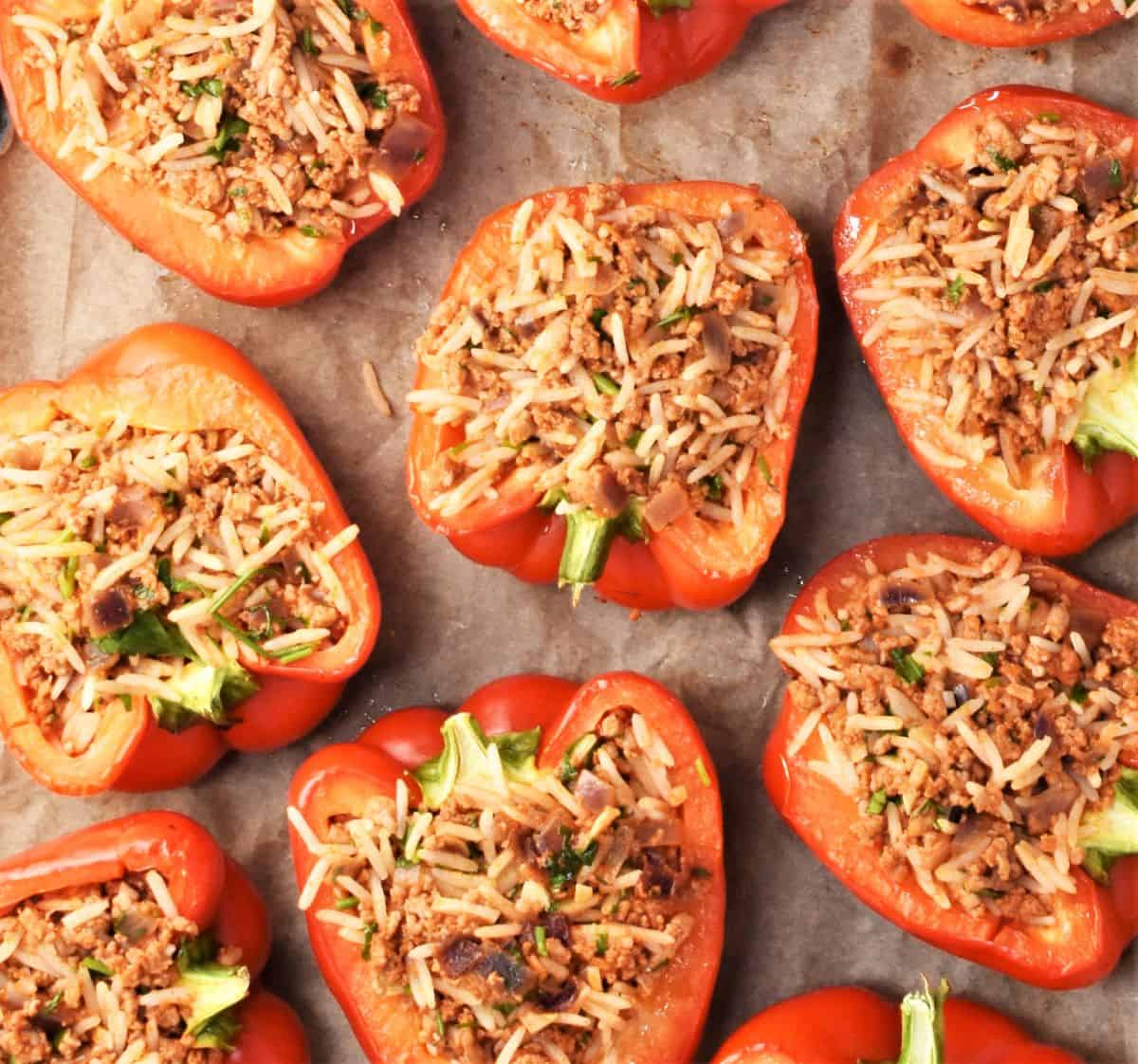 Stuffed pepper halves with turkey and rice on top of parchment.