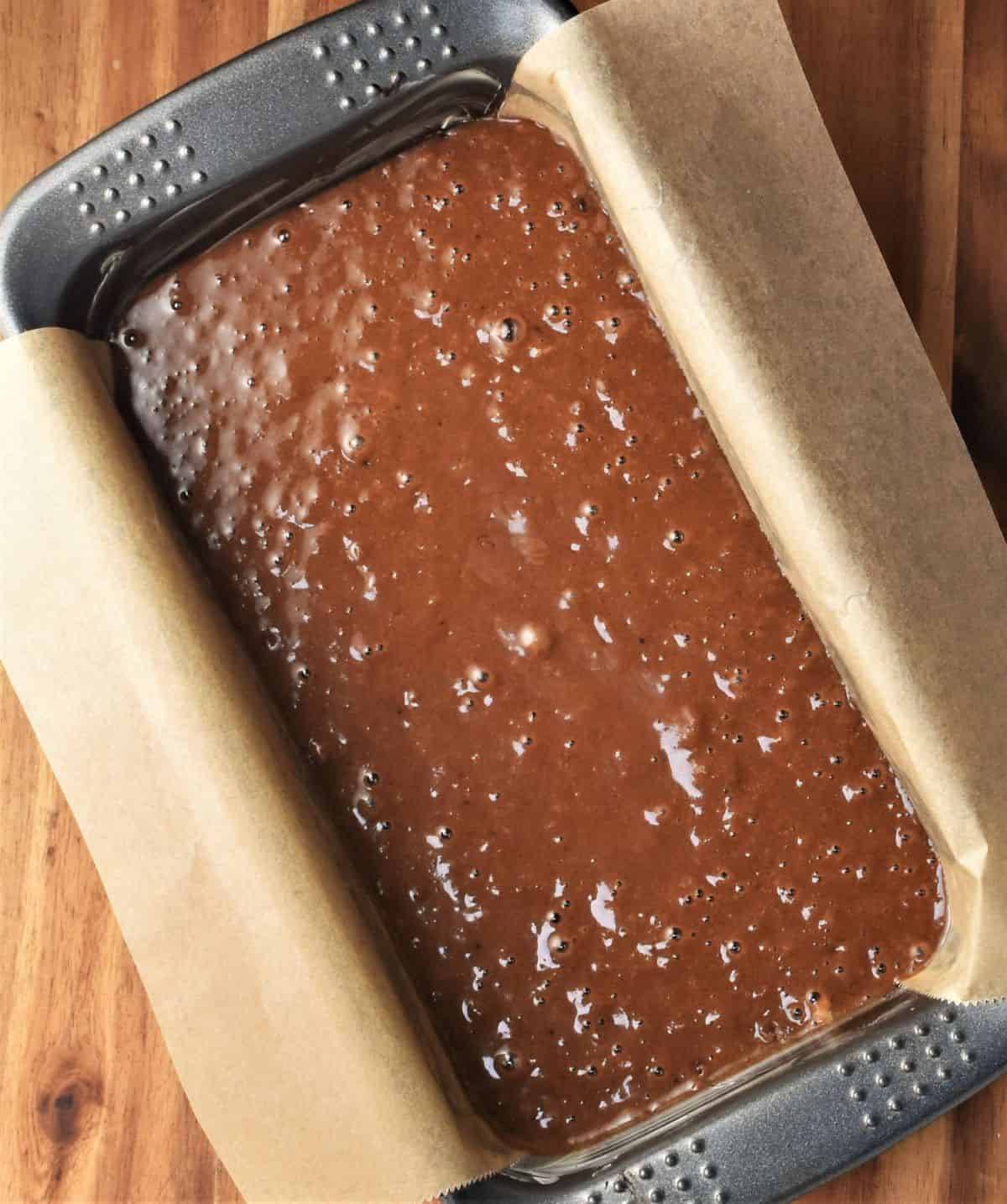 Gingerbread batter in loaf pan lined with parchment.