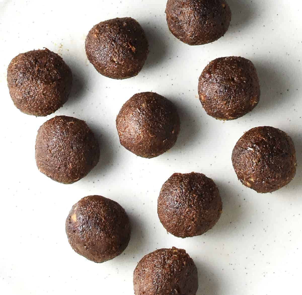 Top down view of quinoa chocolate coffee balls on white plate.