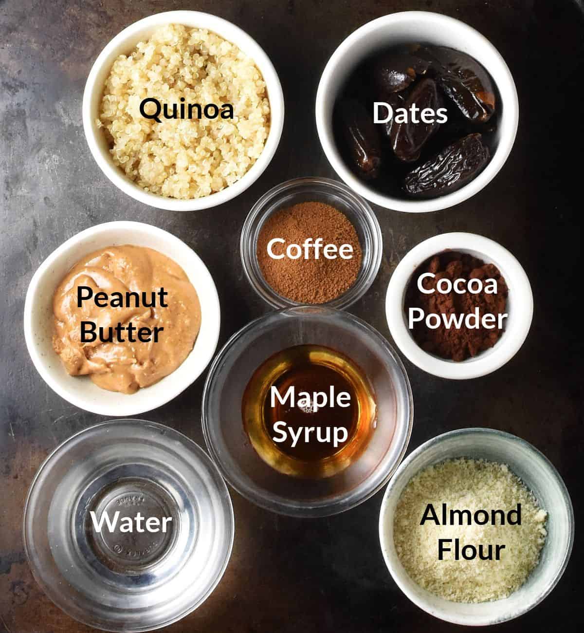 Top down view of quinoa energy balls ingredients in small, labelled dishes.