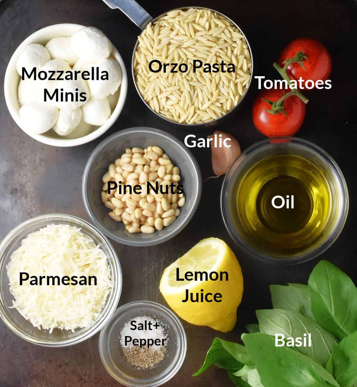 Top down view of ingredients for caprese orzo salad with pesto close together in individual dishes.