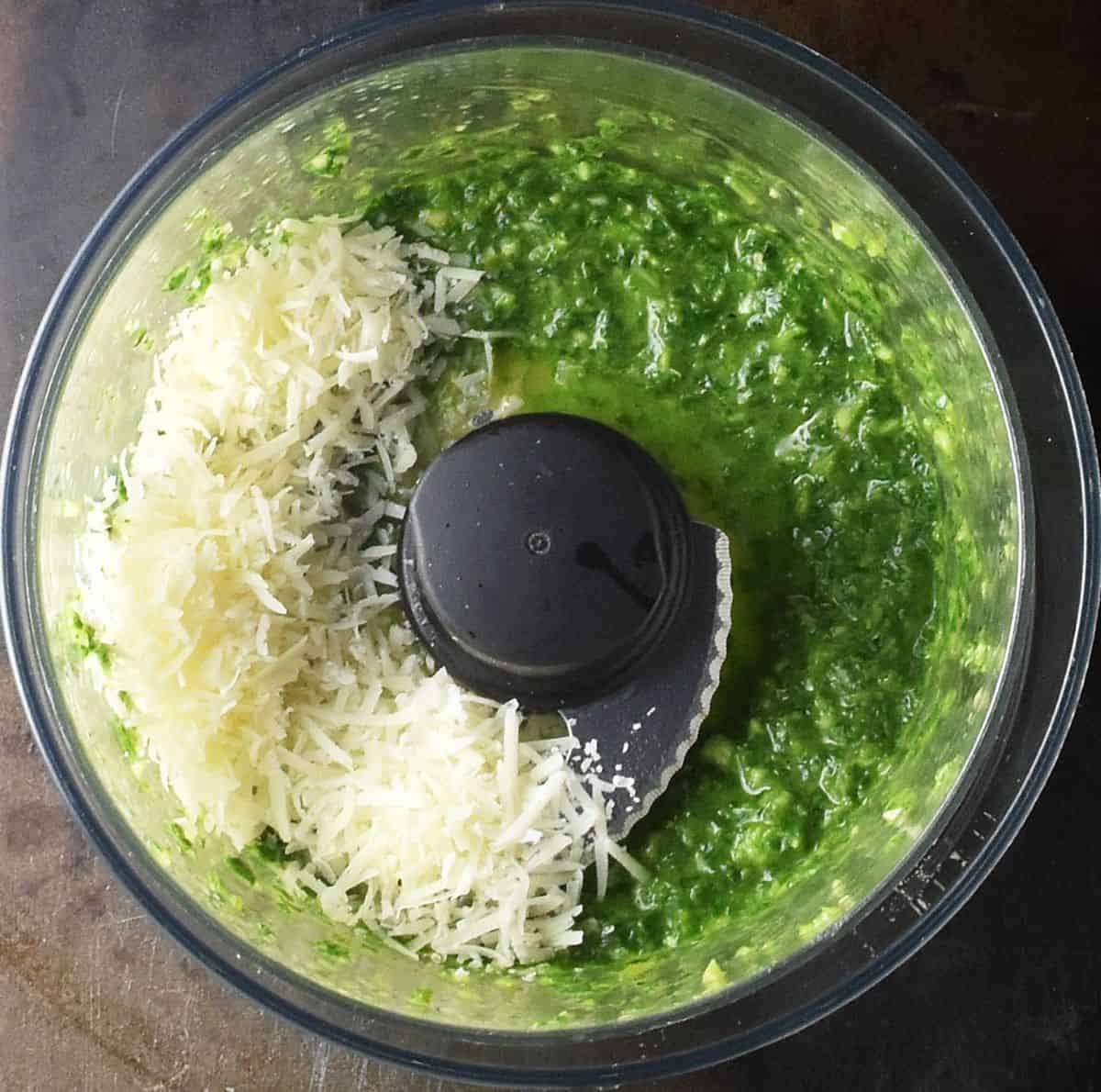 Pesto with shredded cheese in blender.