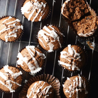 Top down view of gingerbread muffins with icing on top of rack and tray.