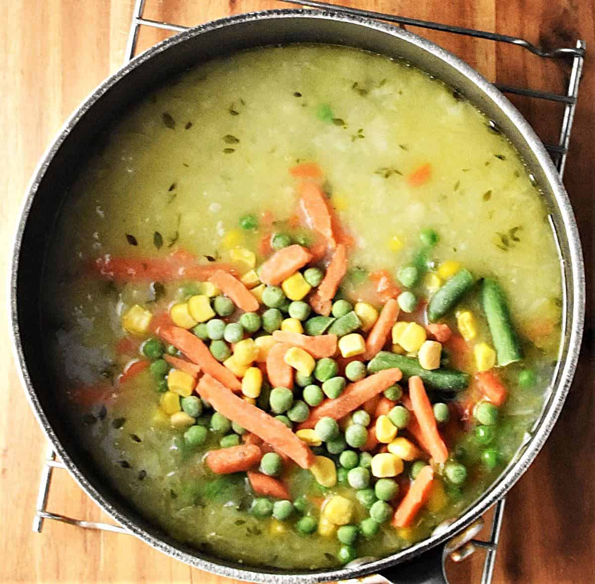 Creamy soup with turkey and vegetables in large pot.