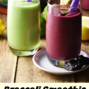 Side view of purple and green smoothies in glasses with purple straws.