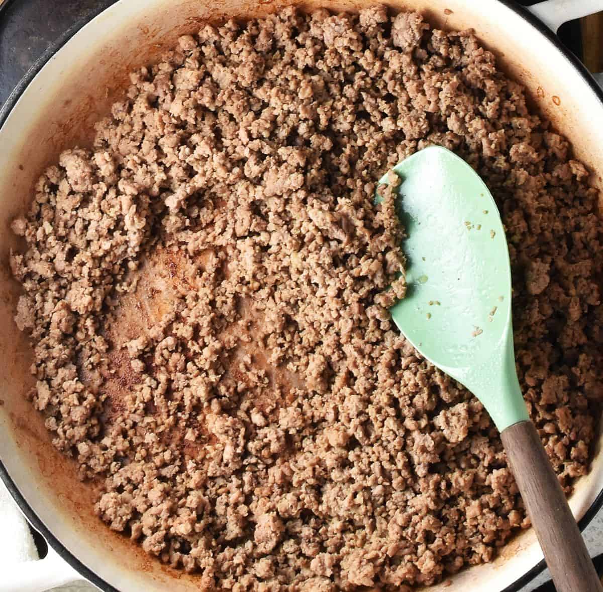 Cooked ground turkey in round large pan with spatula.