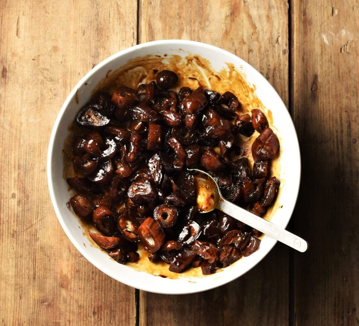 Chopped dates and coffee in white bowl with spoon.