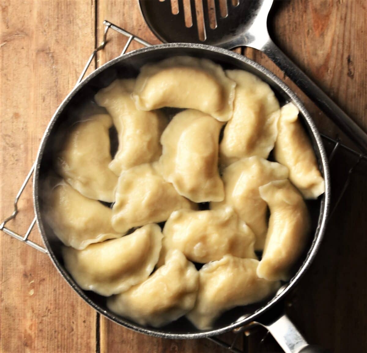 Boiling perogies in pot.