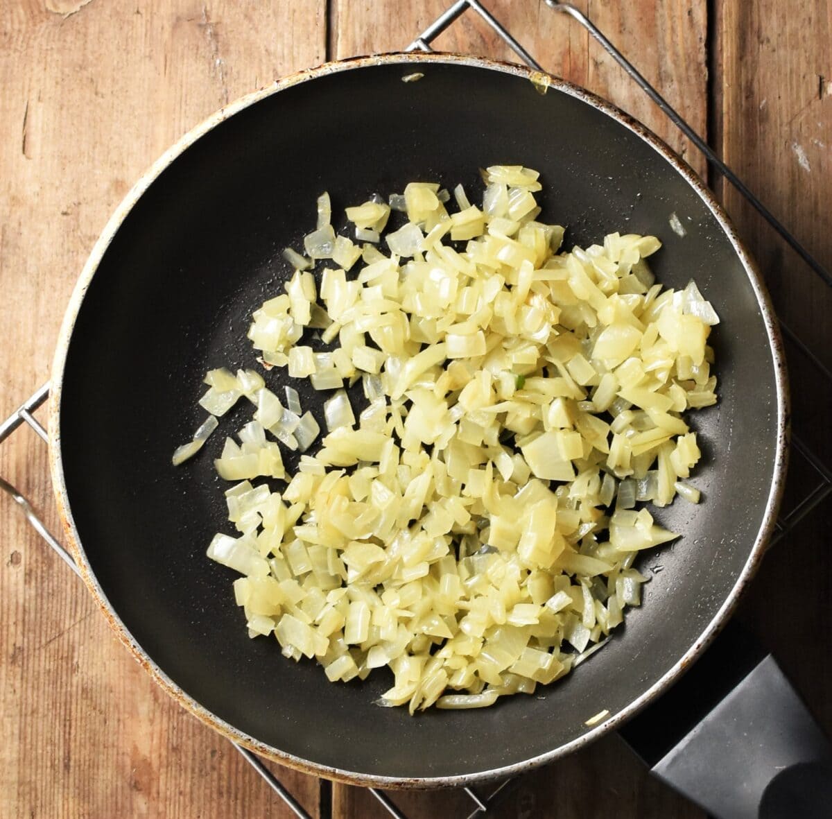 Finely chopped fried onion in pan.