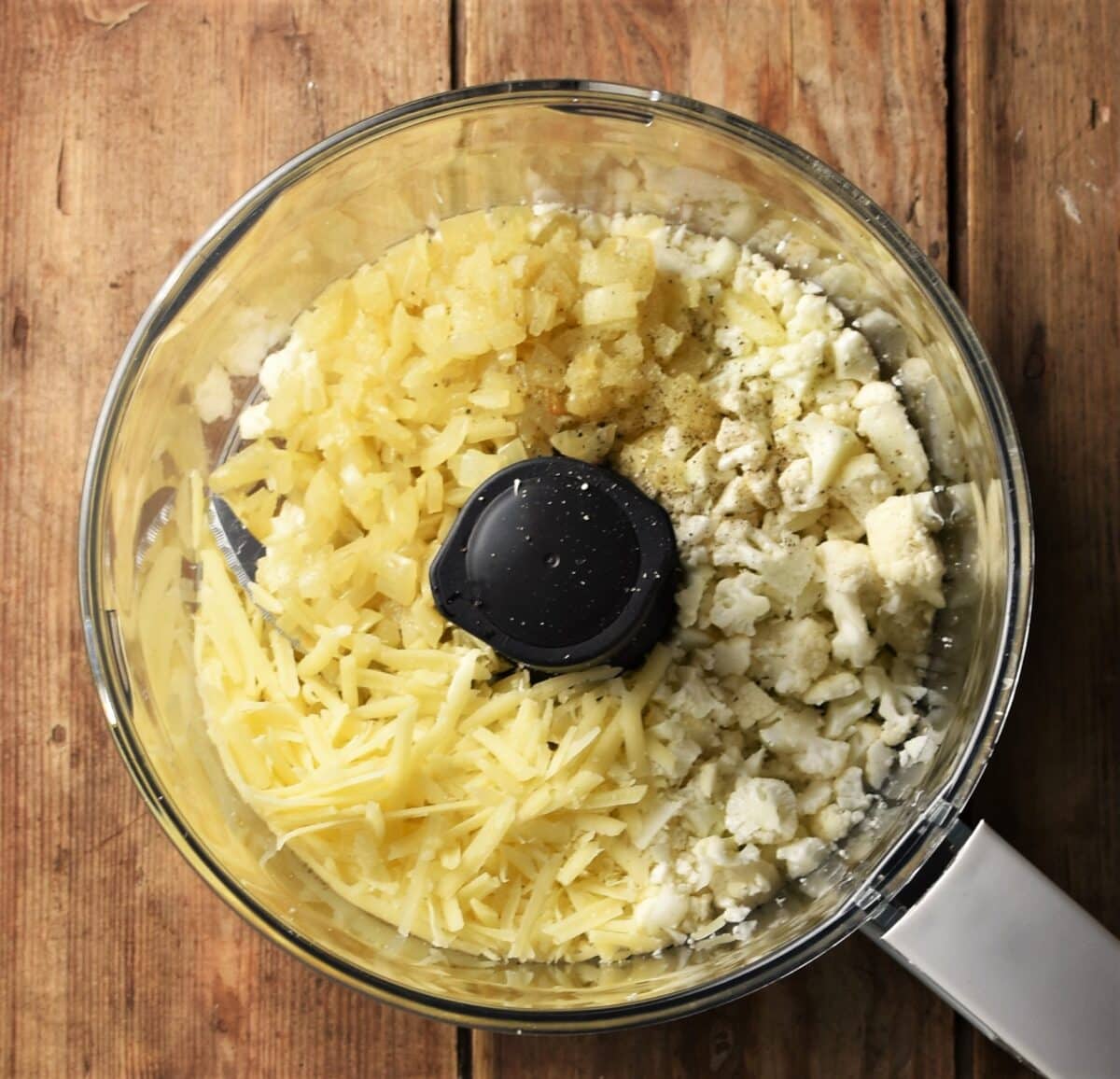 Grated cheese, chopped cauliflower and onion in blender.