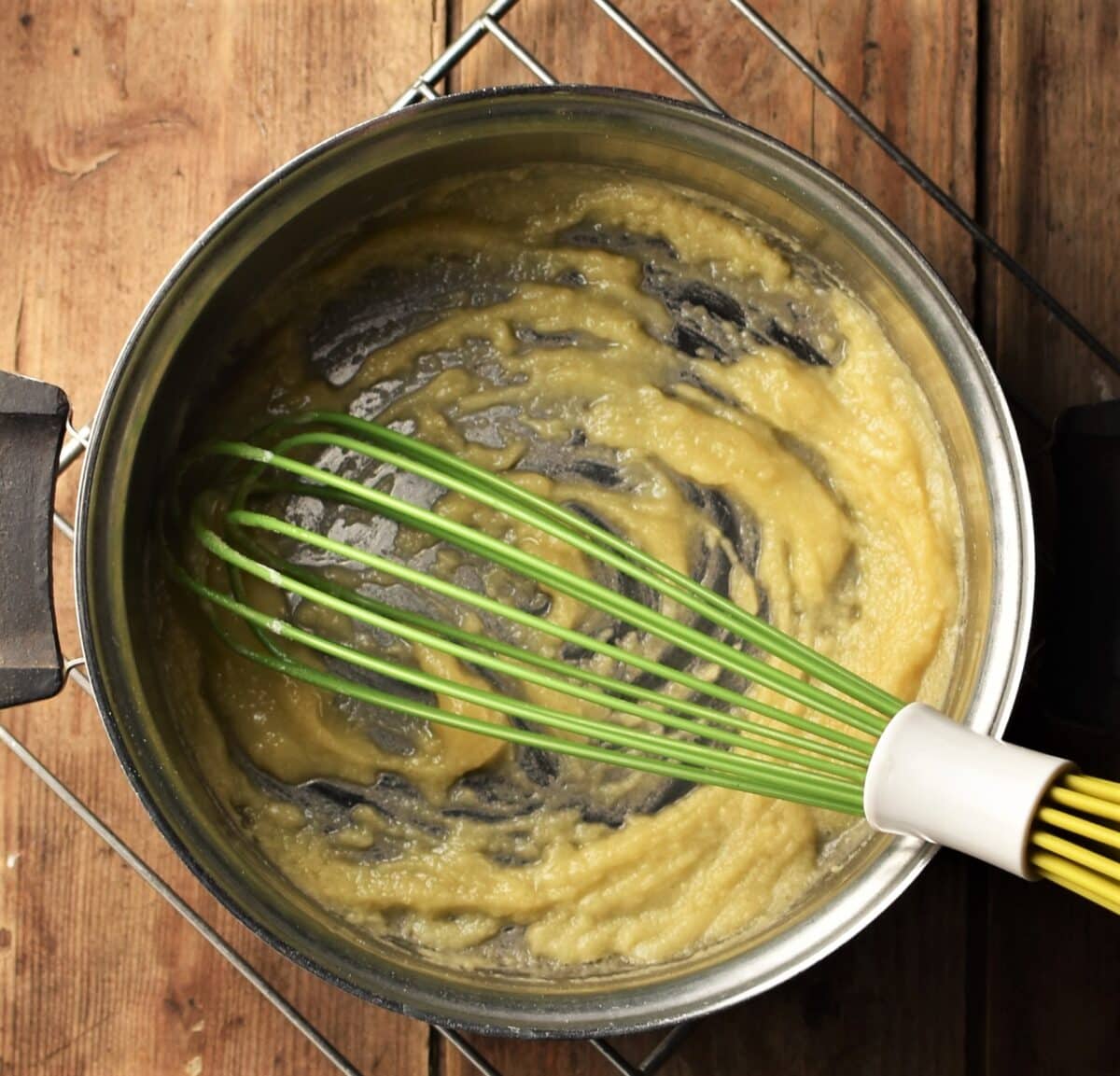 Roux in saucepan with green whisk.