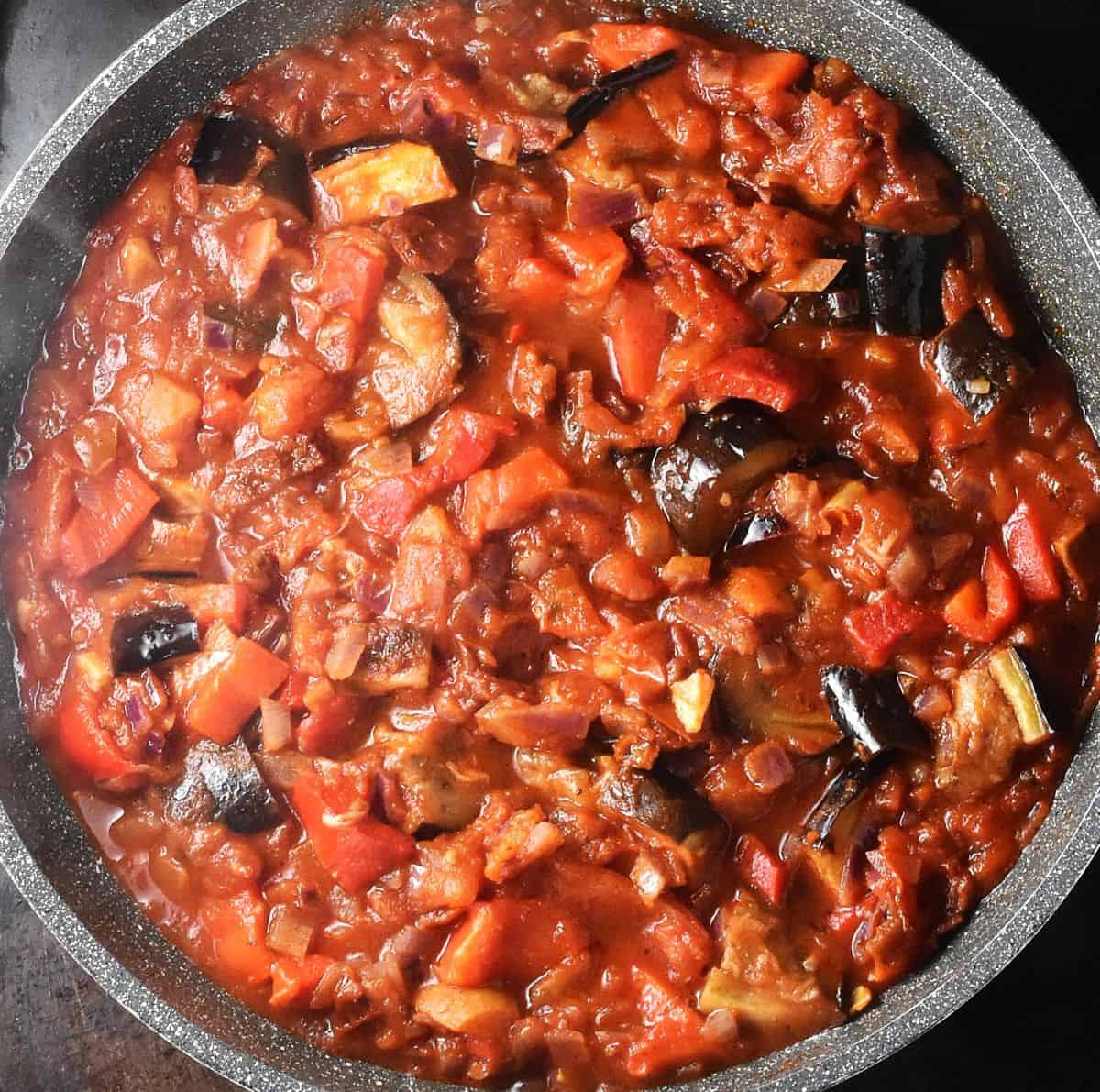 Top down view of chunky eggplant pasta sauce in large pan.
