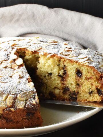 Side view of marzipan cake on white plate.