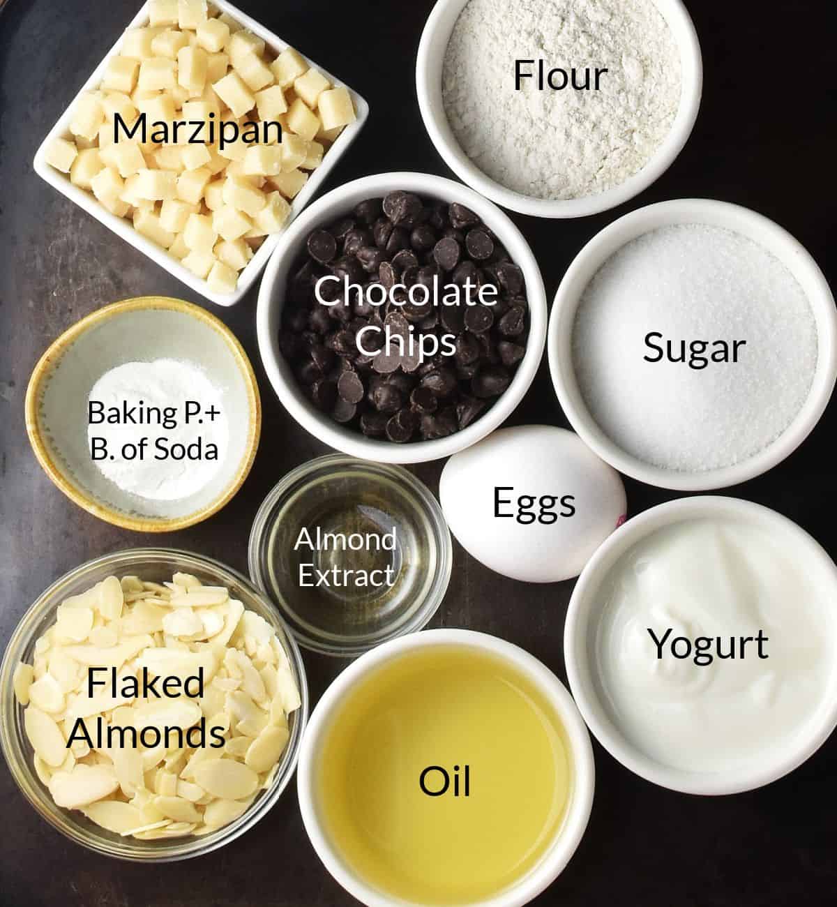 Top down view of marzipan cake ingredients in individual small dishes.