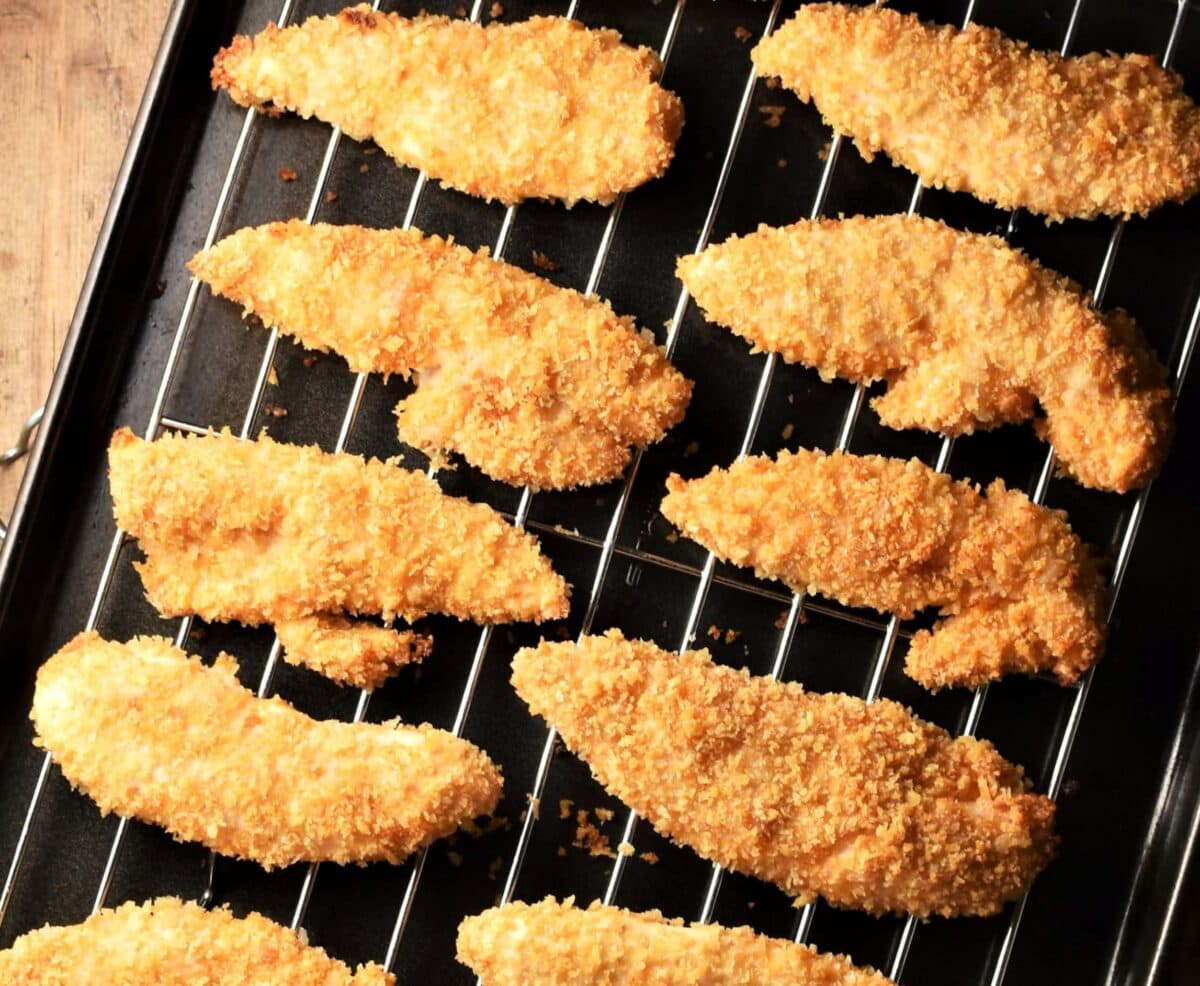 Crispy chicken tenders on top of rack.