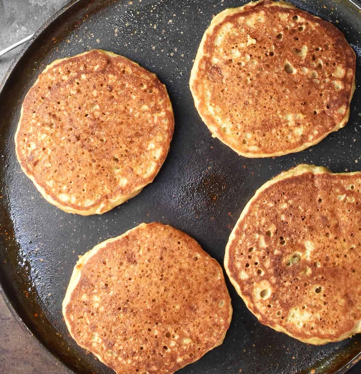 Top down view of 4 pancakes in large pan.
