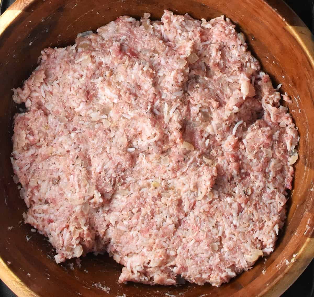 Cabbage rolls filling mixture in large bamboo bowl.
