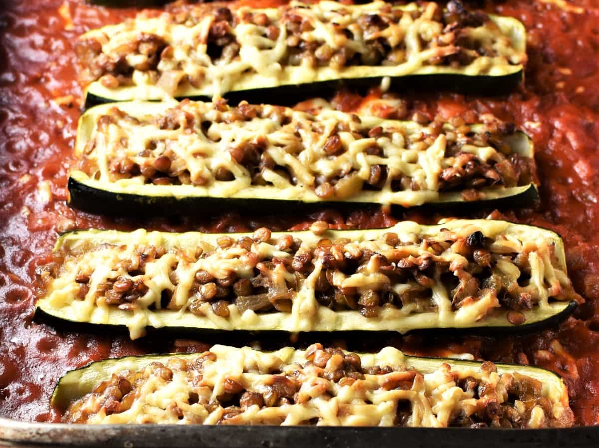 Close-up view of lentil stuffed zucchini in tomato sauce.