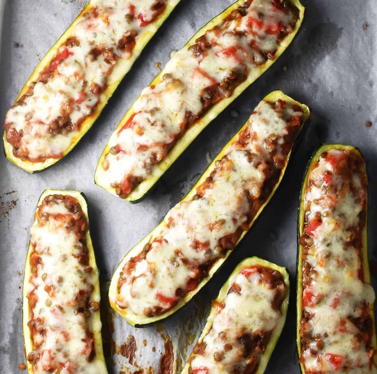 Top down view of baked vegetarian zucchini boats with melted cheese on top.
