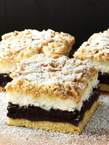 Side view of 3 plesniak cake slices on top of wooden surface.