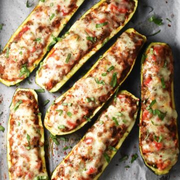 Top down view of vegetarian stuffed zucchini boats on top of parchment.