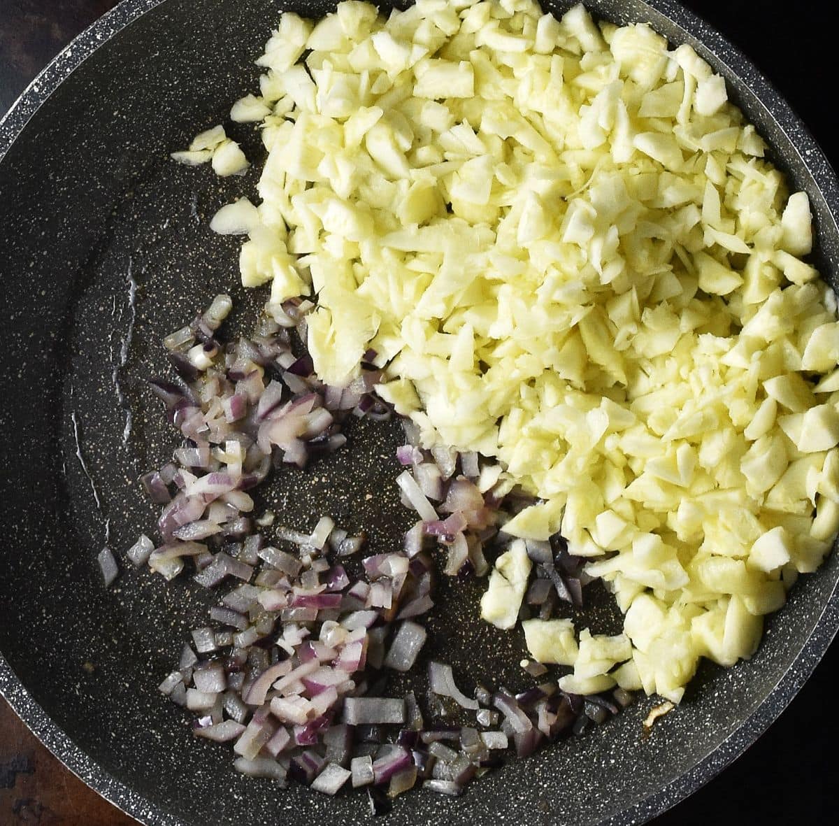 Chopped red onion and zucchini pulp in large pan.