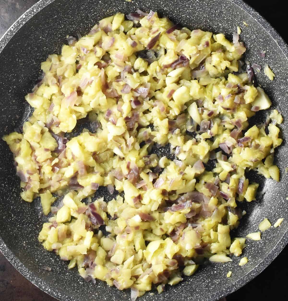 Chopped zucchini pulp and red onion in large pan.