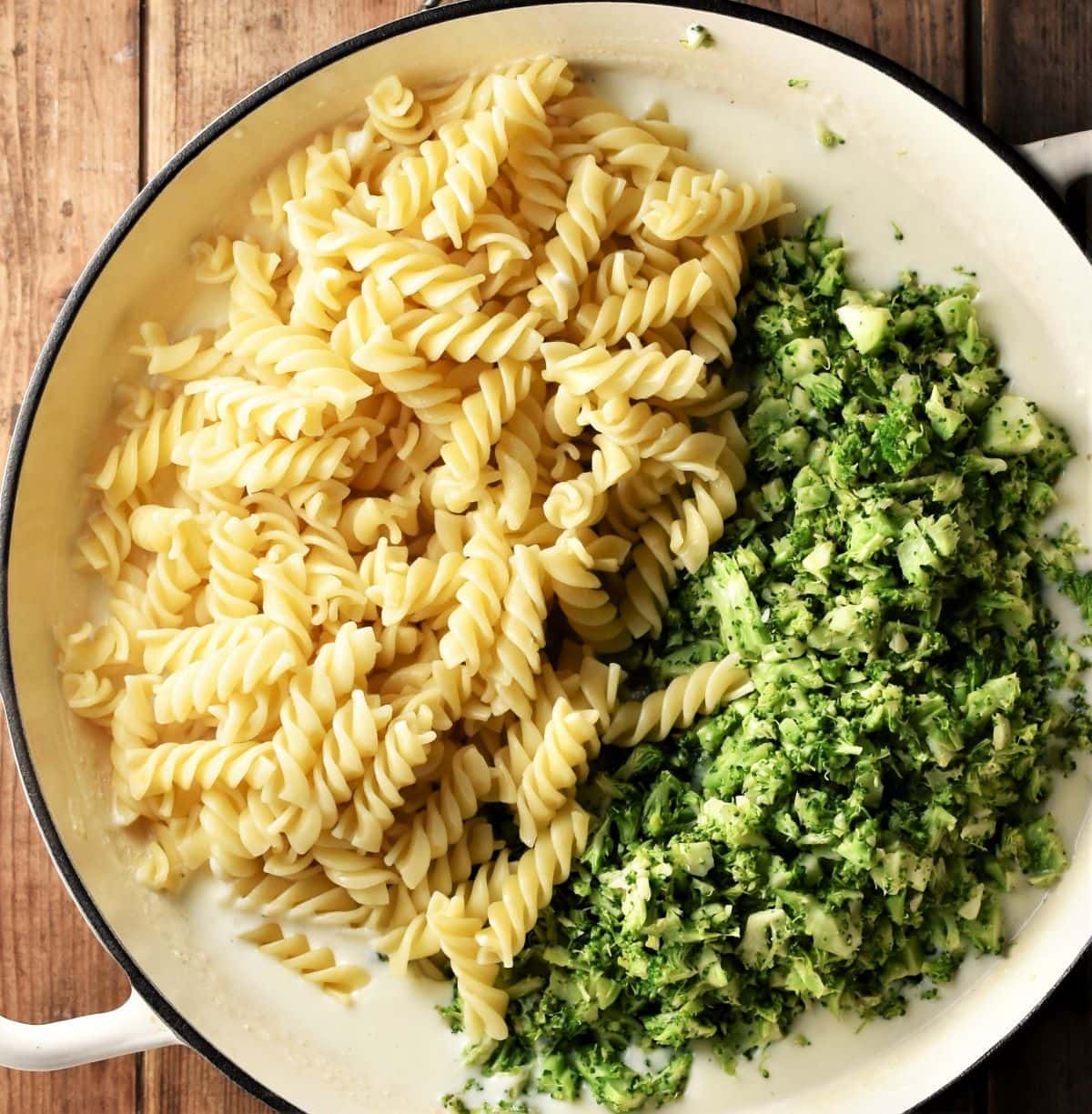 Fusilli pasta and broccoli rice in large shallow pan.