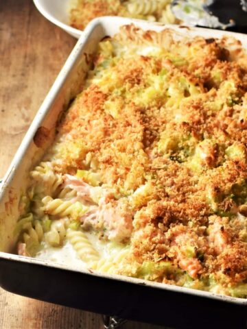 Side angle view of salmon pasta bake in rectangular dish.