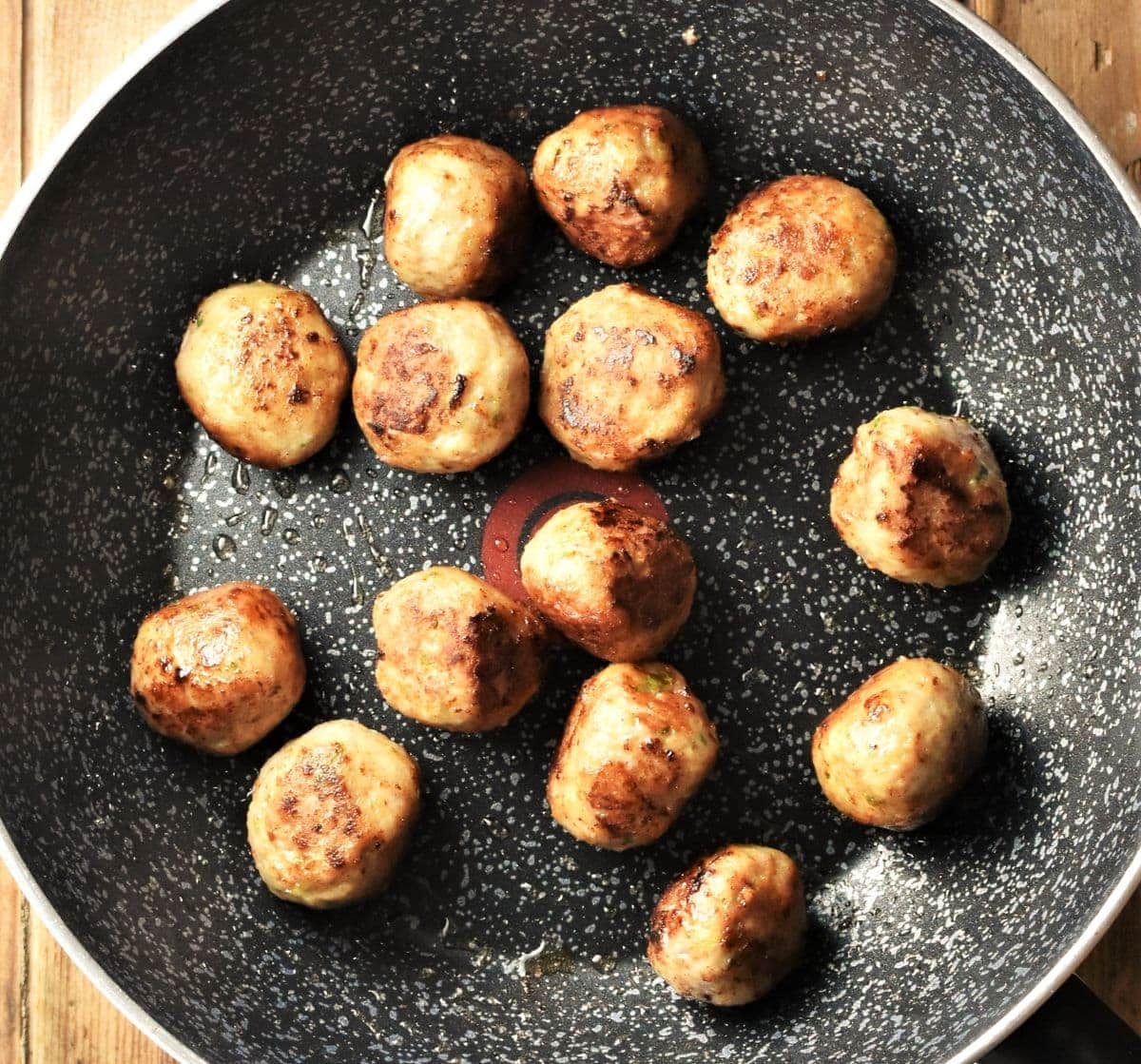 Fried meatballs in large pan.