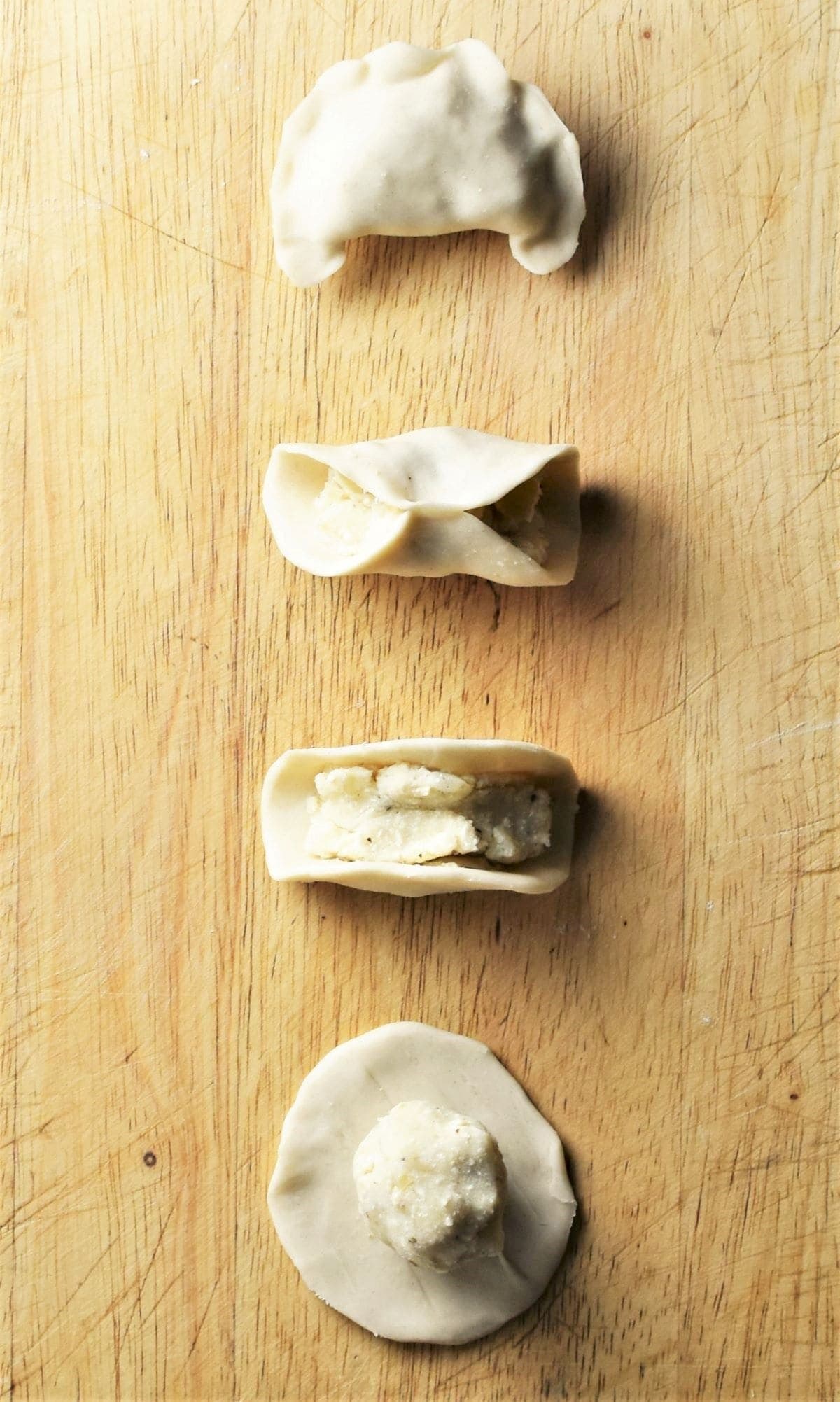Making pierogi on top of wooden board.
