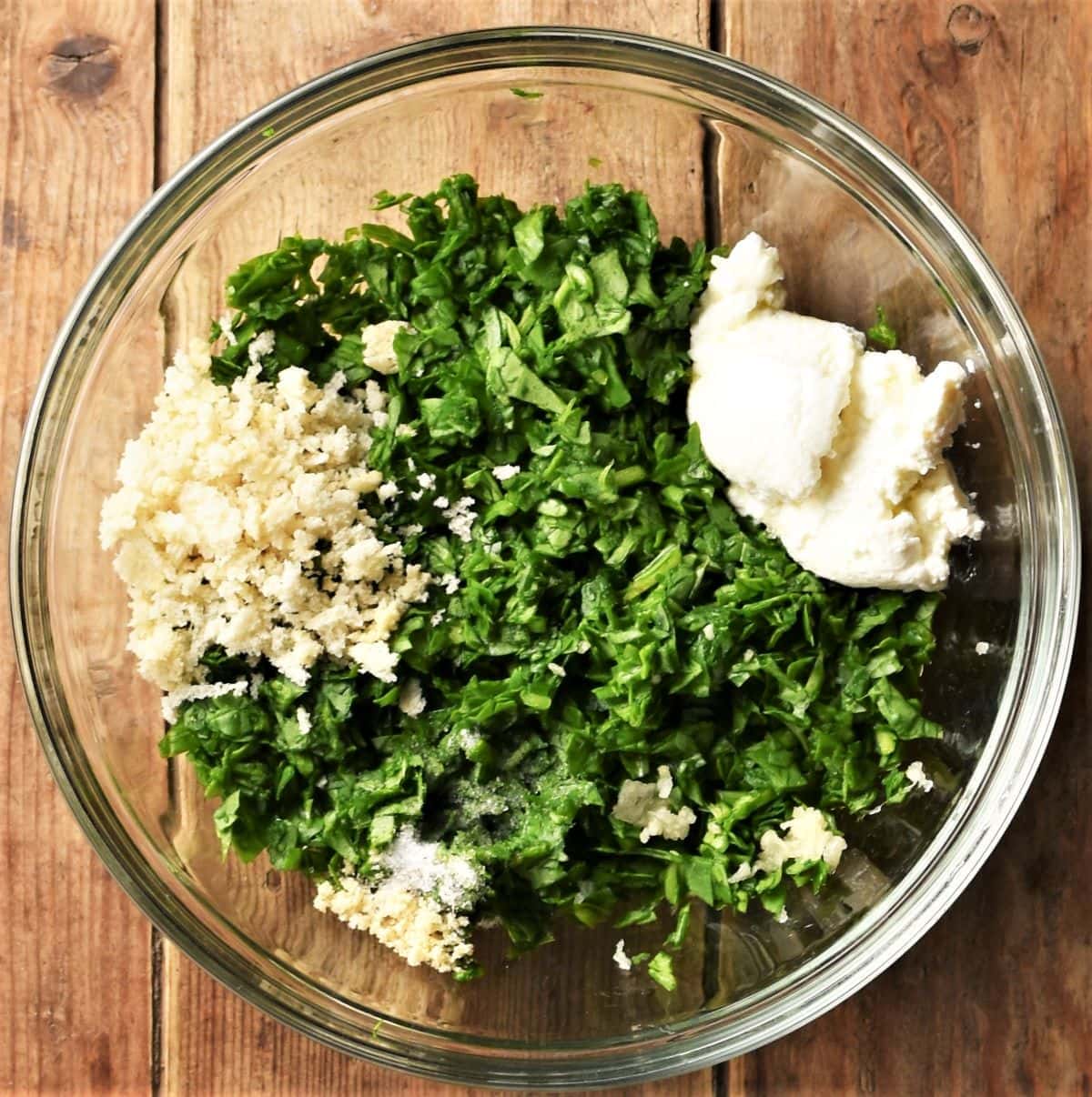 Spinach mixture with cheese and panko in mixing bowl.