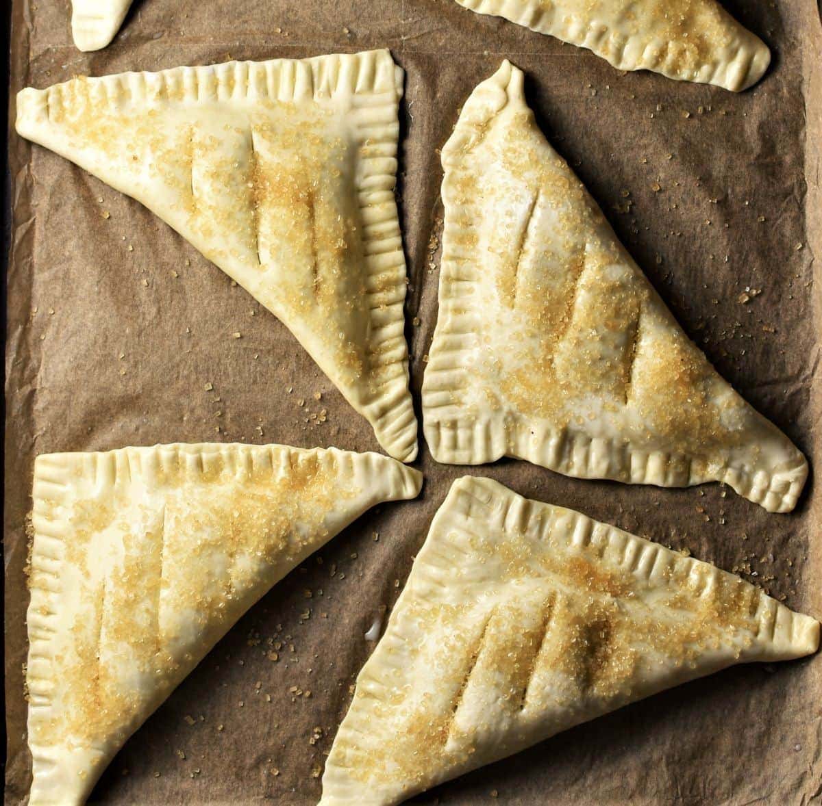 Unbaked turnovers on top of parchment.