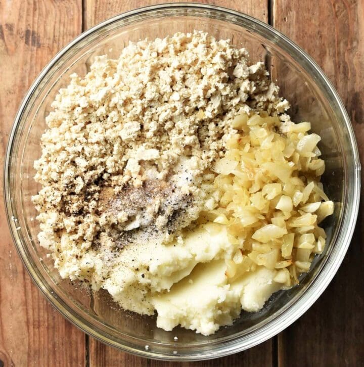 Crumbled tofu, mashed potato and fried onion in mixing bowl.