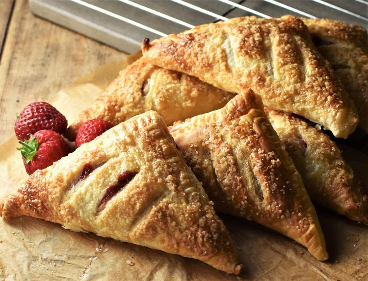 Side view of turnovers with fresh strawberries in background.