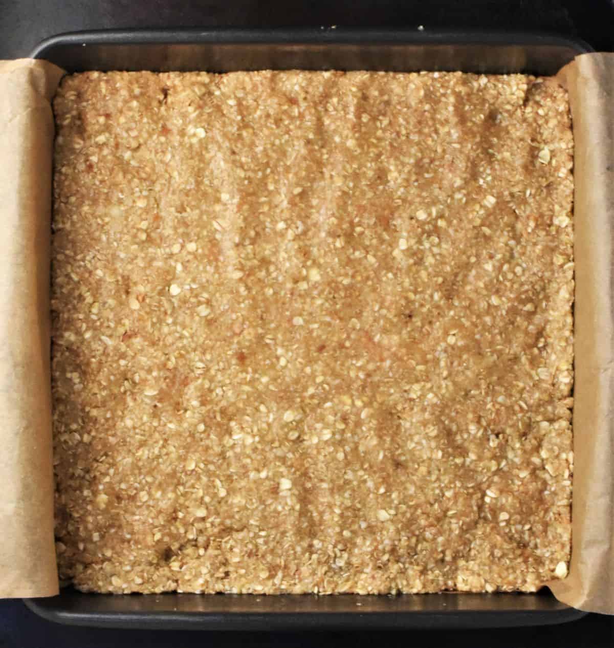 Top down view of oatmeal bars base in square pan.