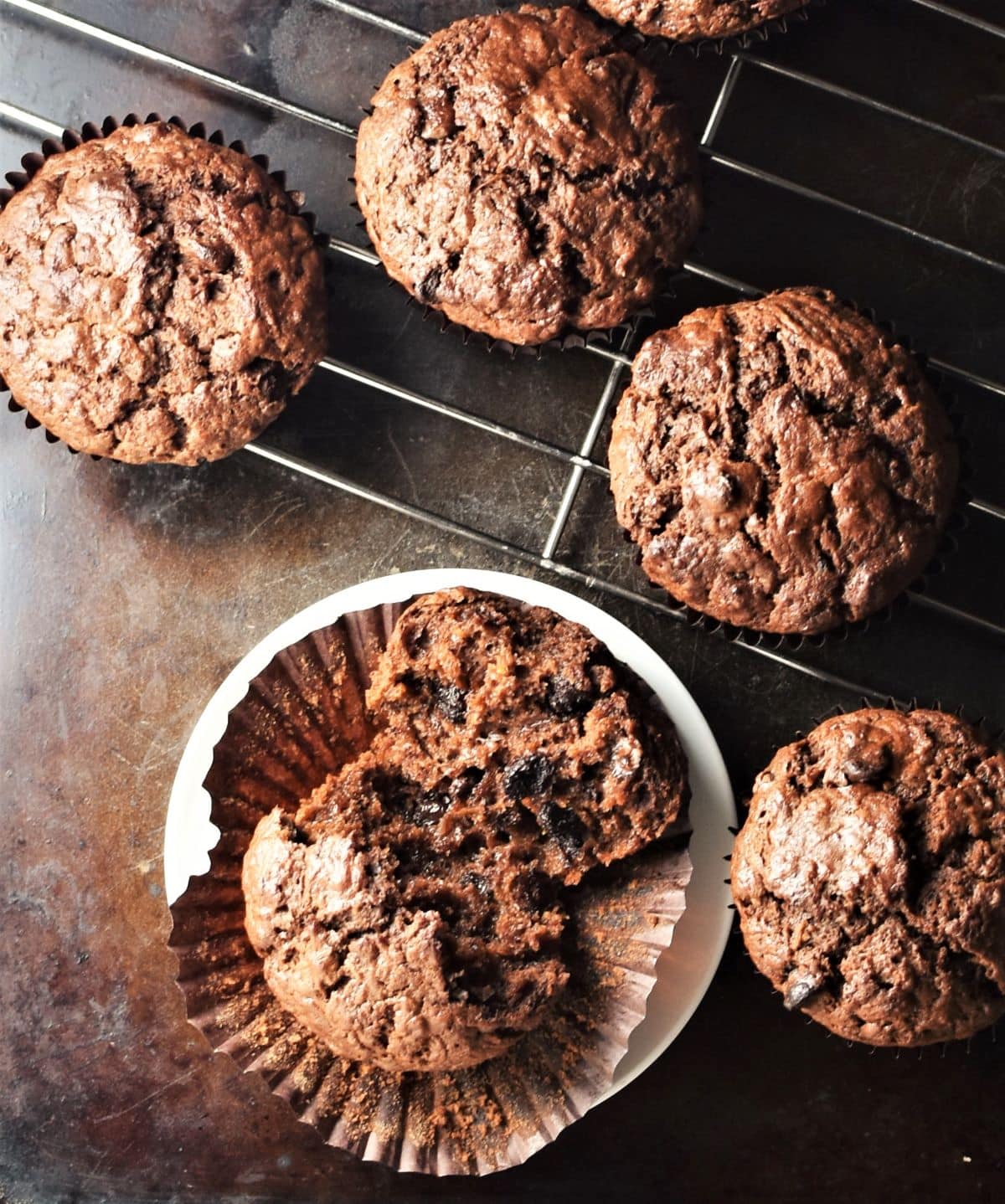 Top down view of chocolate sweet potato muffins on rack.