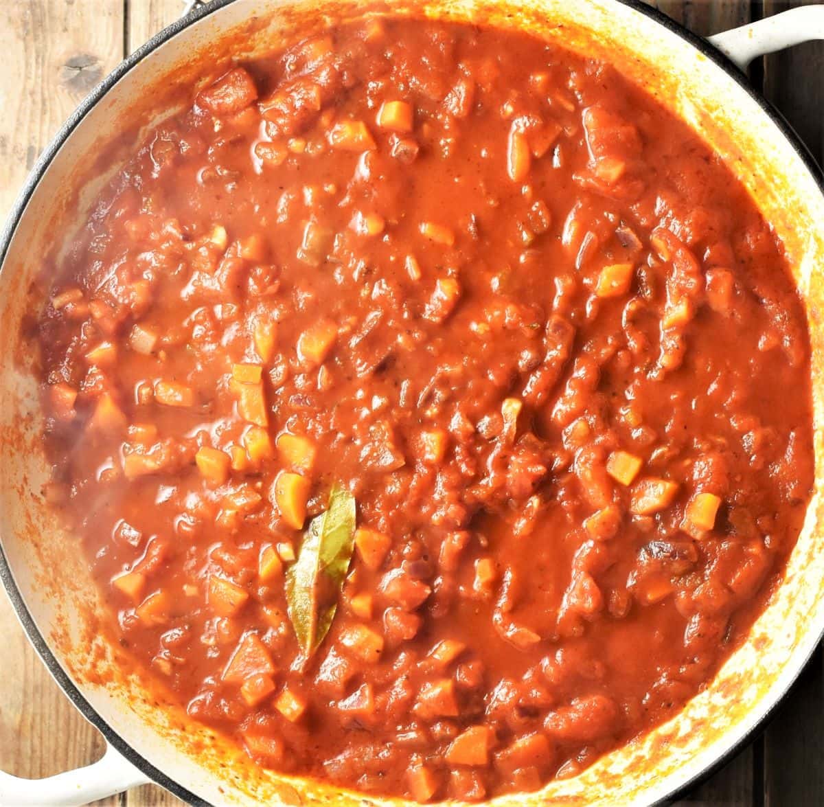 Tomato vegetable sauce in large white pan.