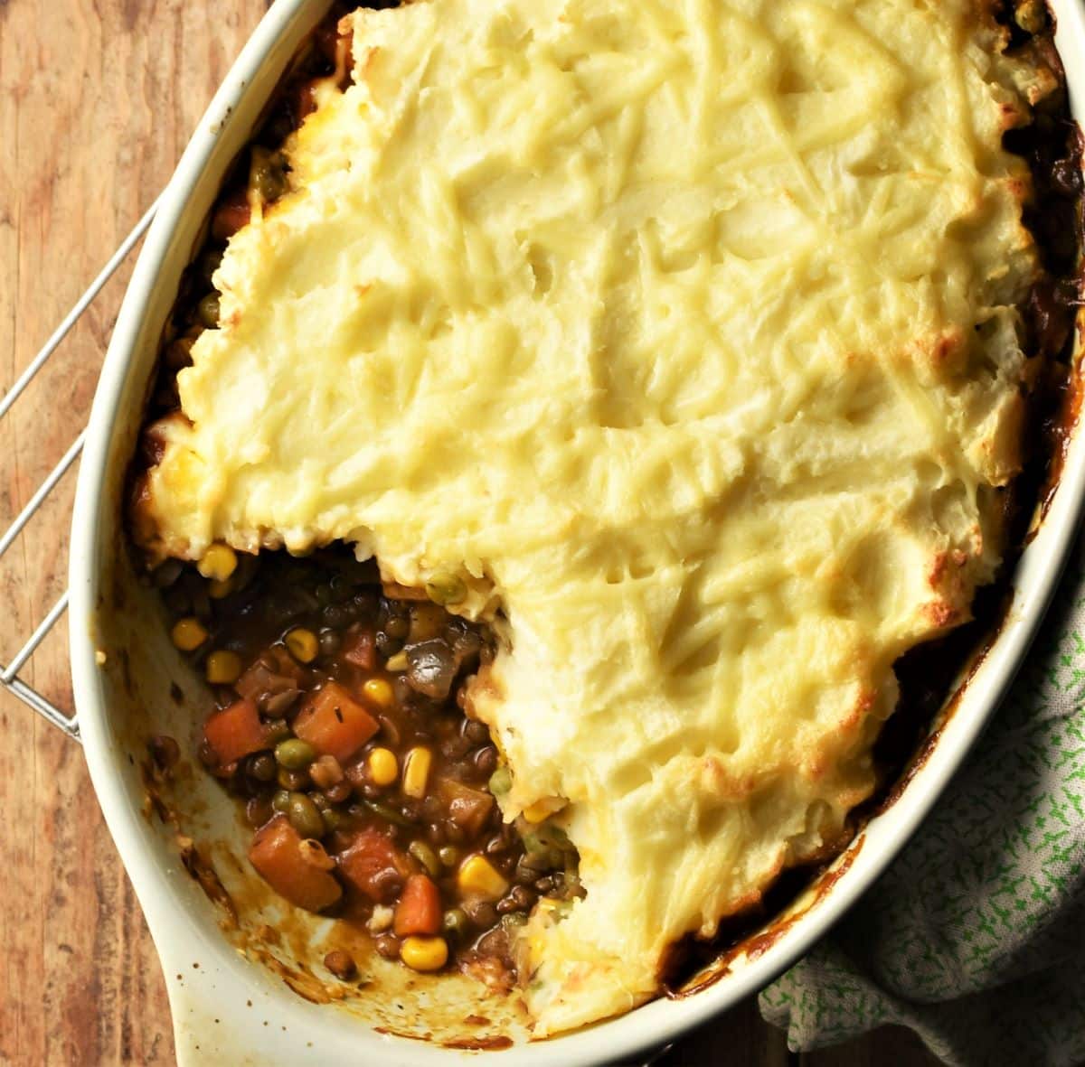 Top down partial view of lentil vegetable shepherd's pie in oval dish.