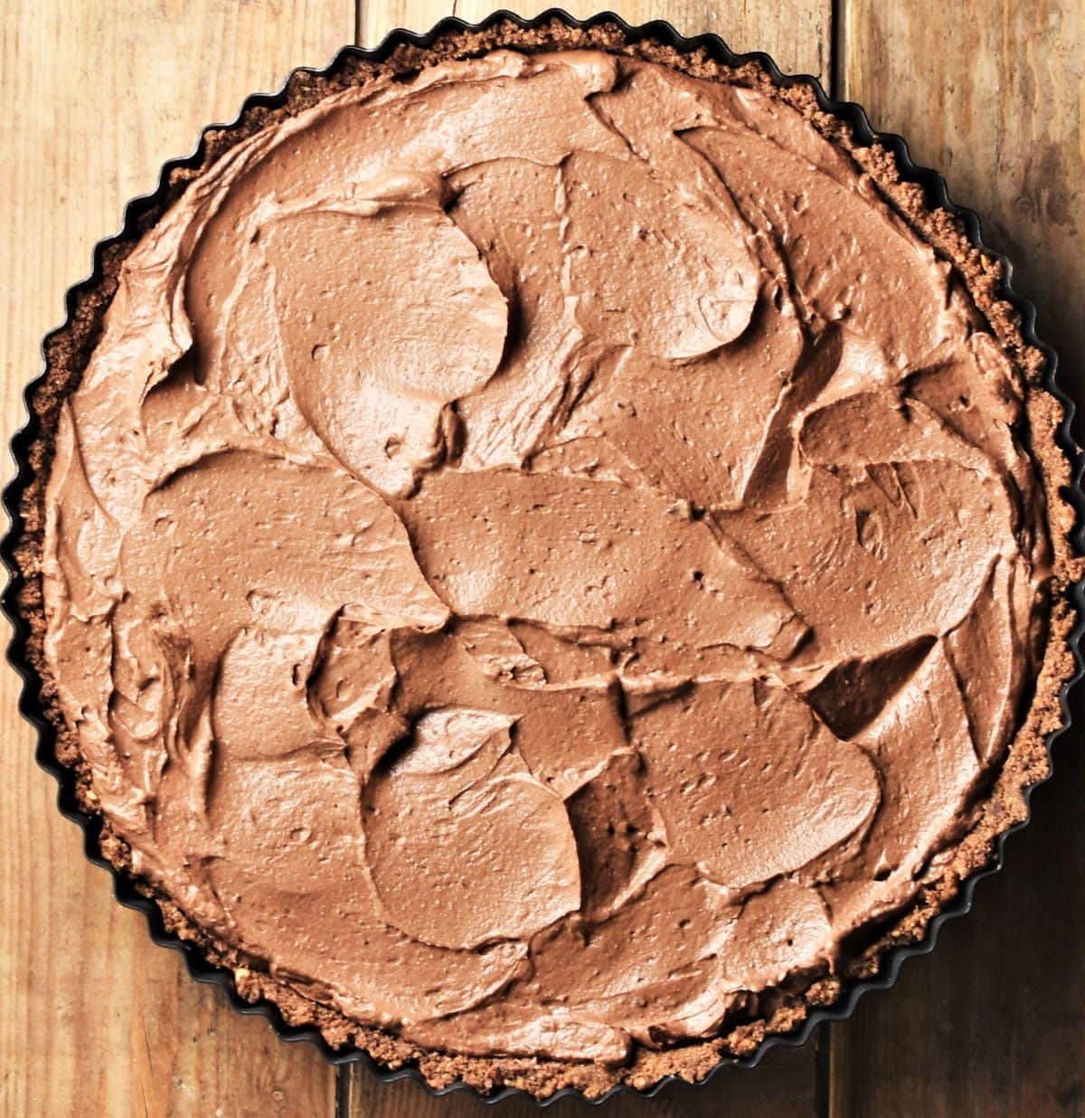 Tart with chocolate filling in round pan.