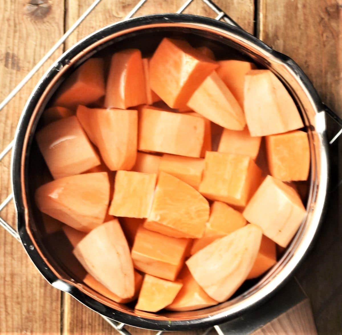 Peeled, cubed sweet potato in saucepan with water.