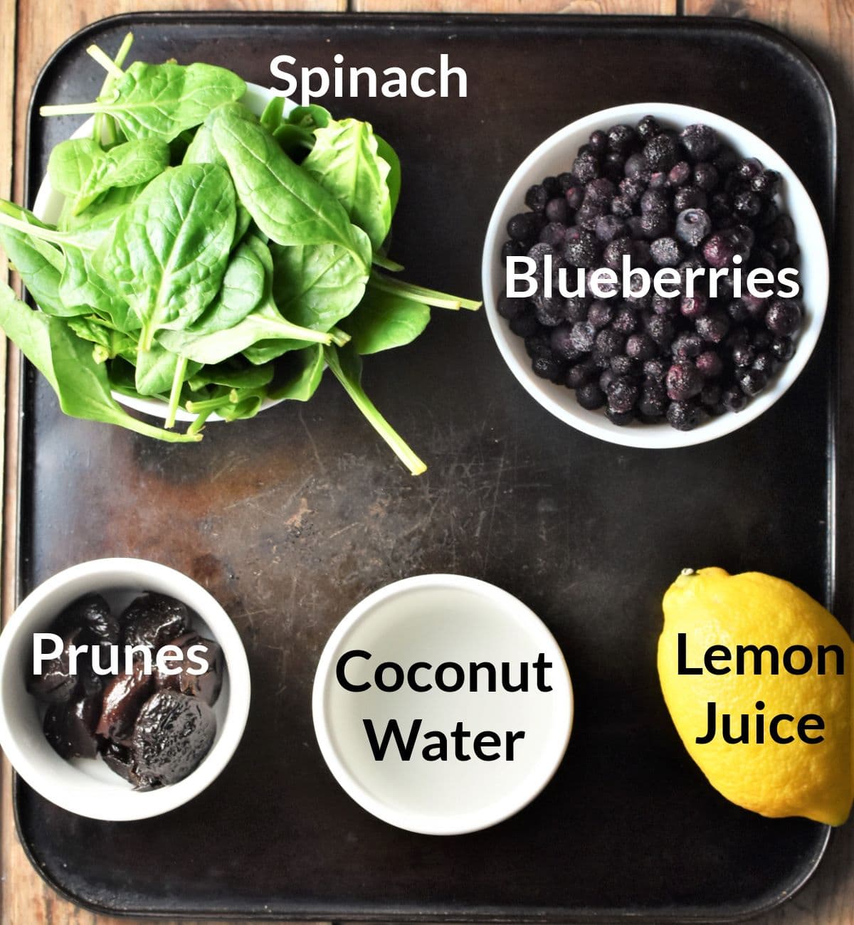 Ingredients for making spinach and blueberry smoothie in individual dishes.