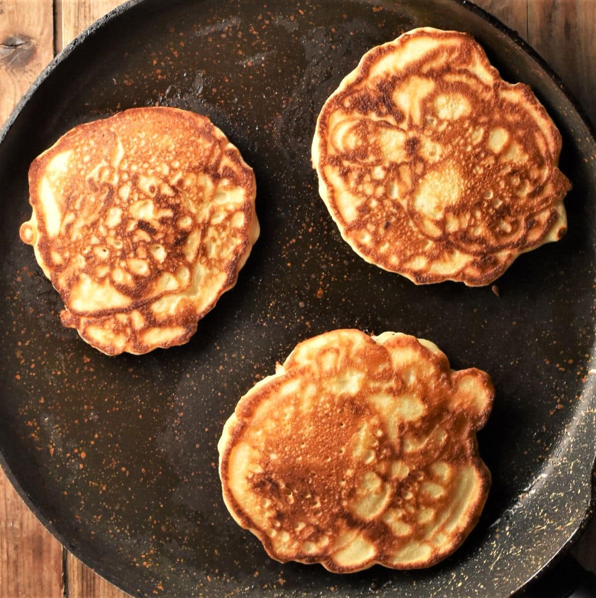 3 pancakes on top of large frying pan.