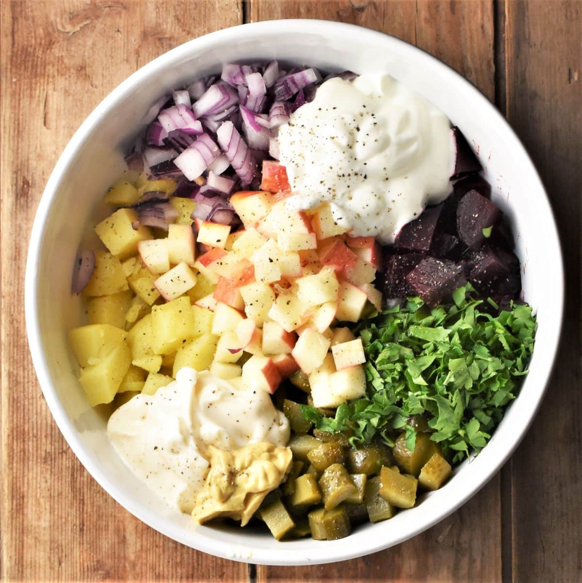 Chopped vegetables, herbs and yogurt in mixing bowl.