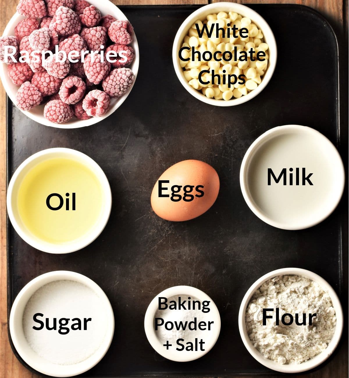 Ingredients for making raspberry white chocolate muffins in individual dishes.