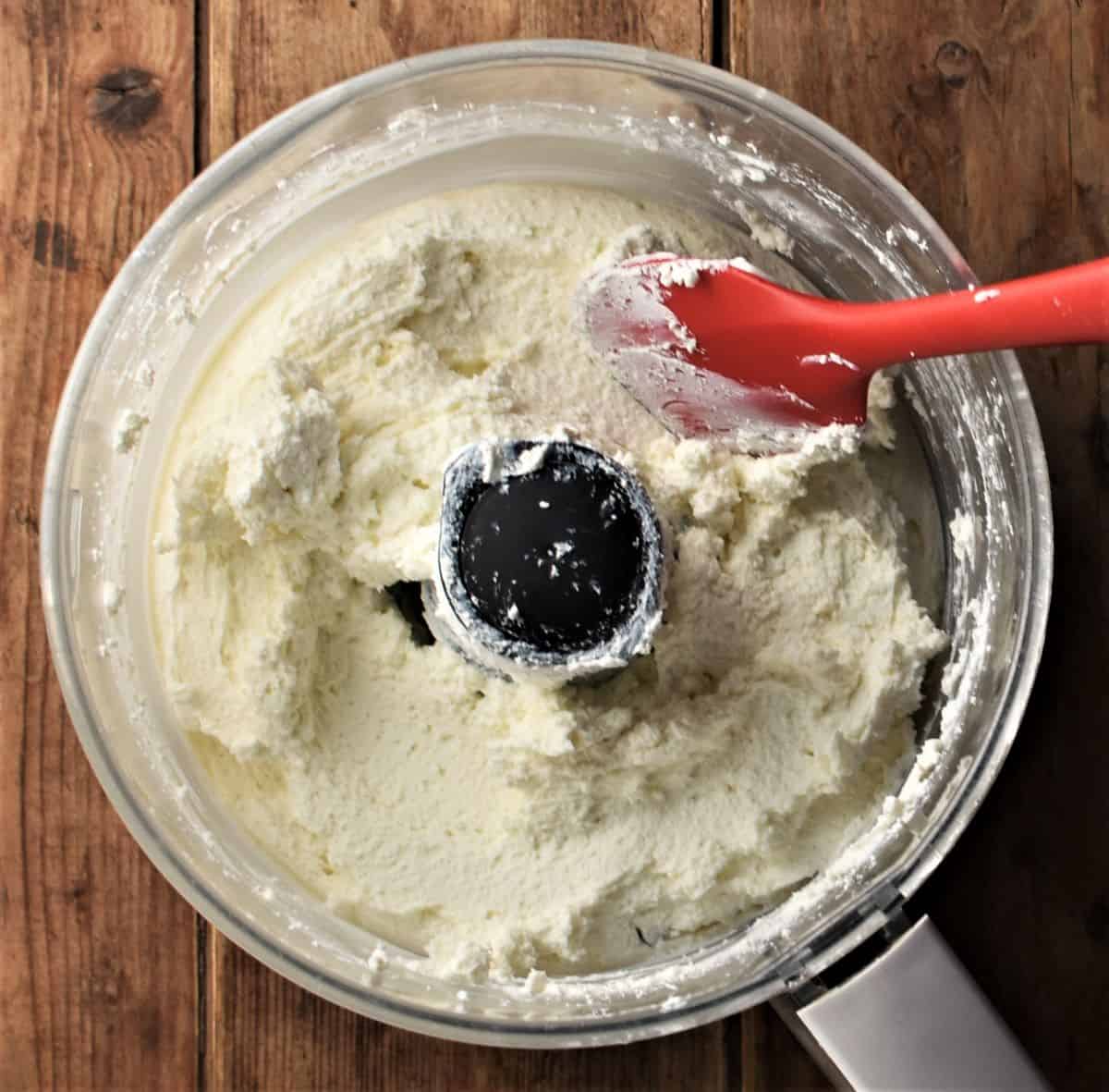 Polish twarog cheese in food processor bowl with red spatula.